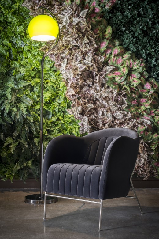 Silla colocada delante de un muro verde artificial